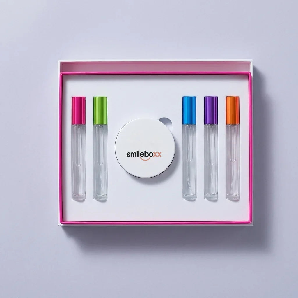 An open white box with magenta trim holding five glass ampoules around a round compact printed smileboxx