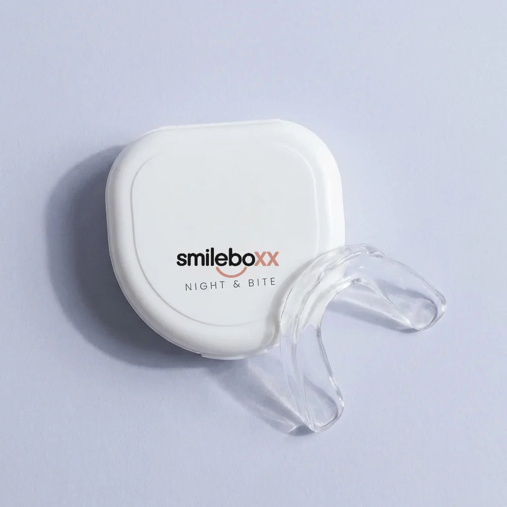 A white case printed smileboxx and NIGHT & BITE beside a clear night guard