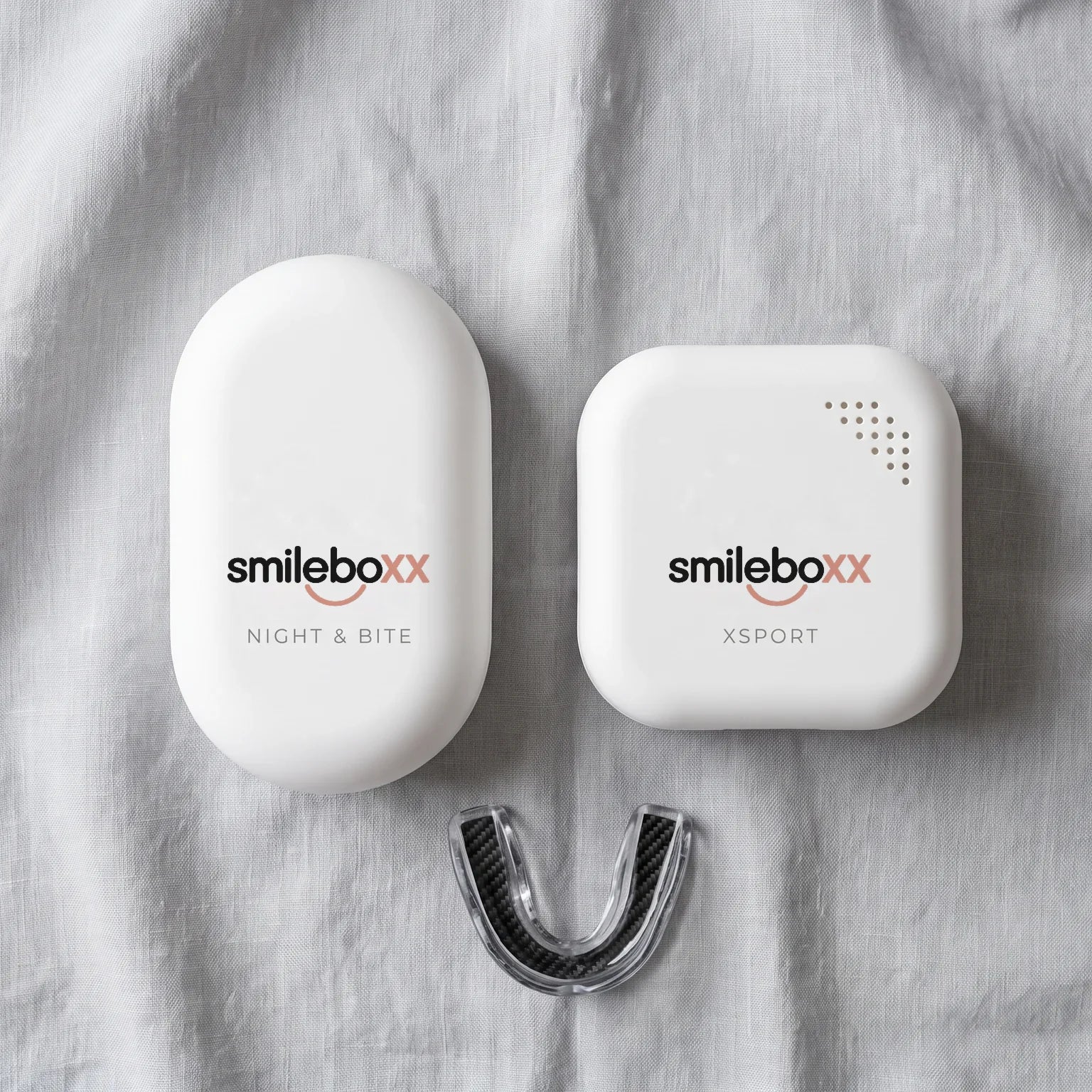 Two guard cases printed smileboxx with NIGHT & BITE and XSPORT on gray linen, with a clear carbon-fiber sports guard