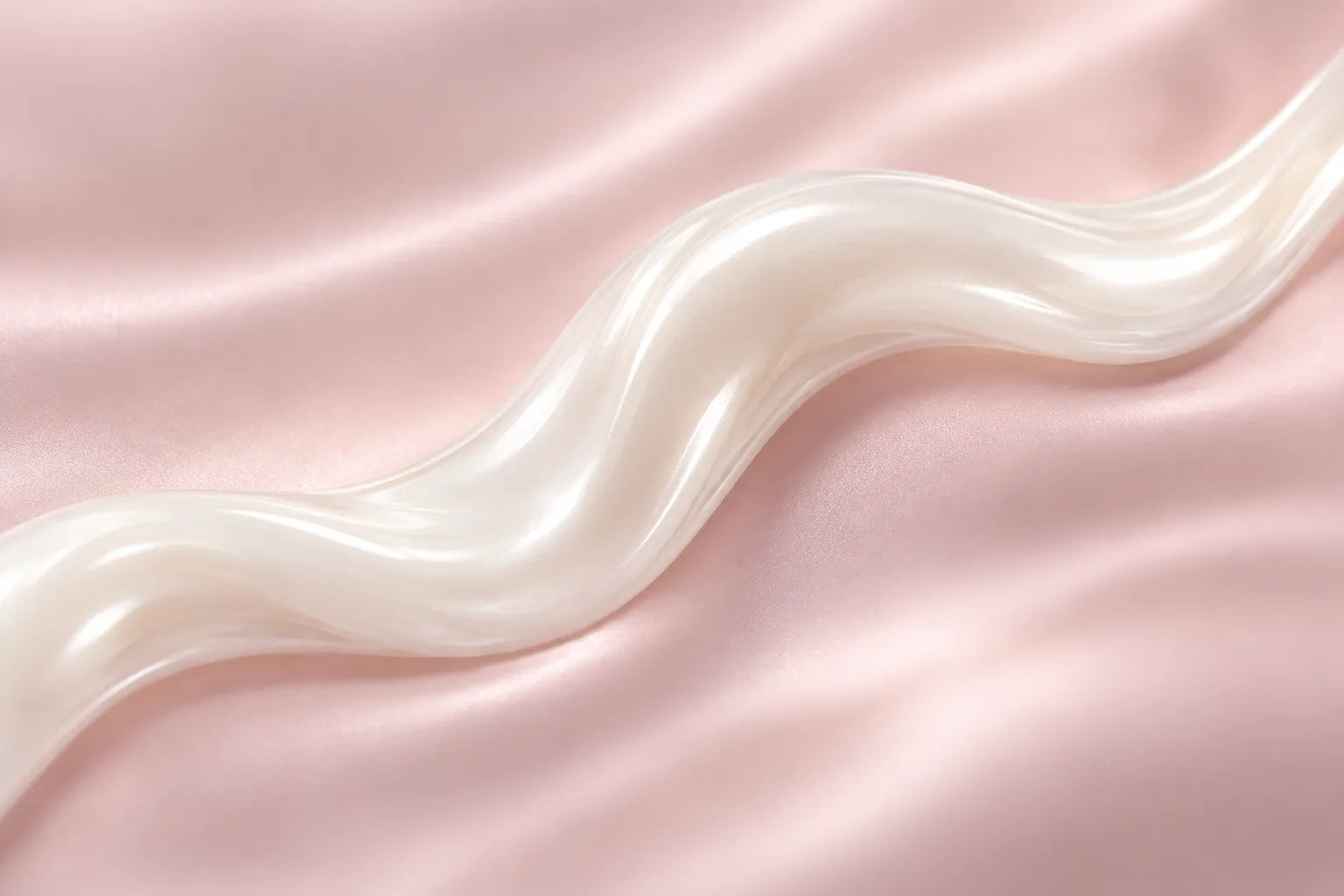 A ribbon of glossy pearl-white liquid curving across blush-pink satin